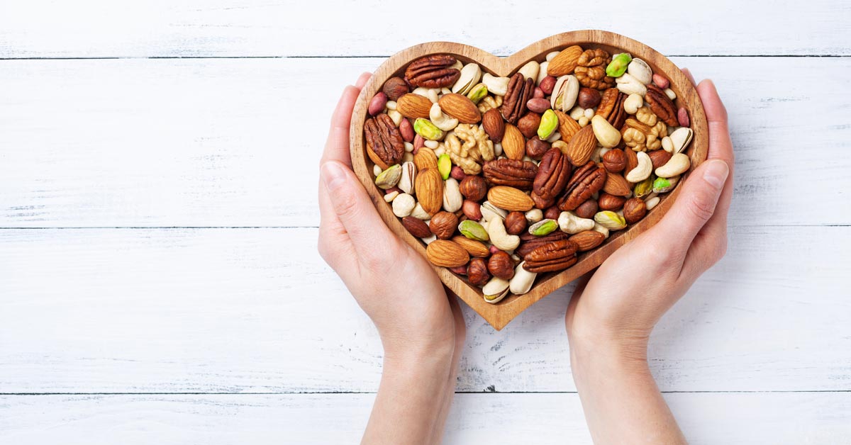 A heart shaped bowl filled with nuts